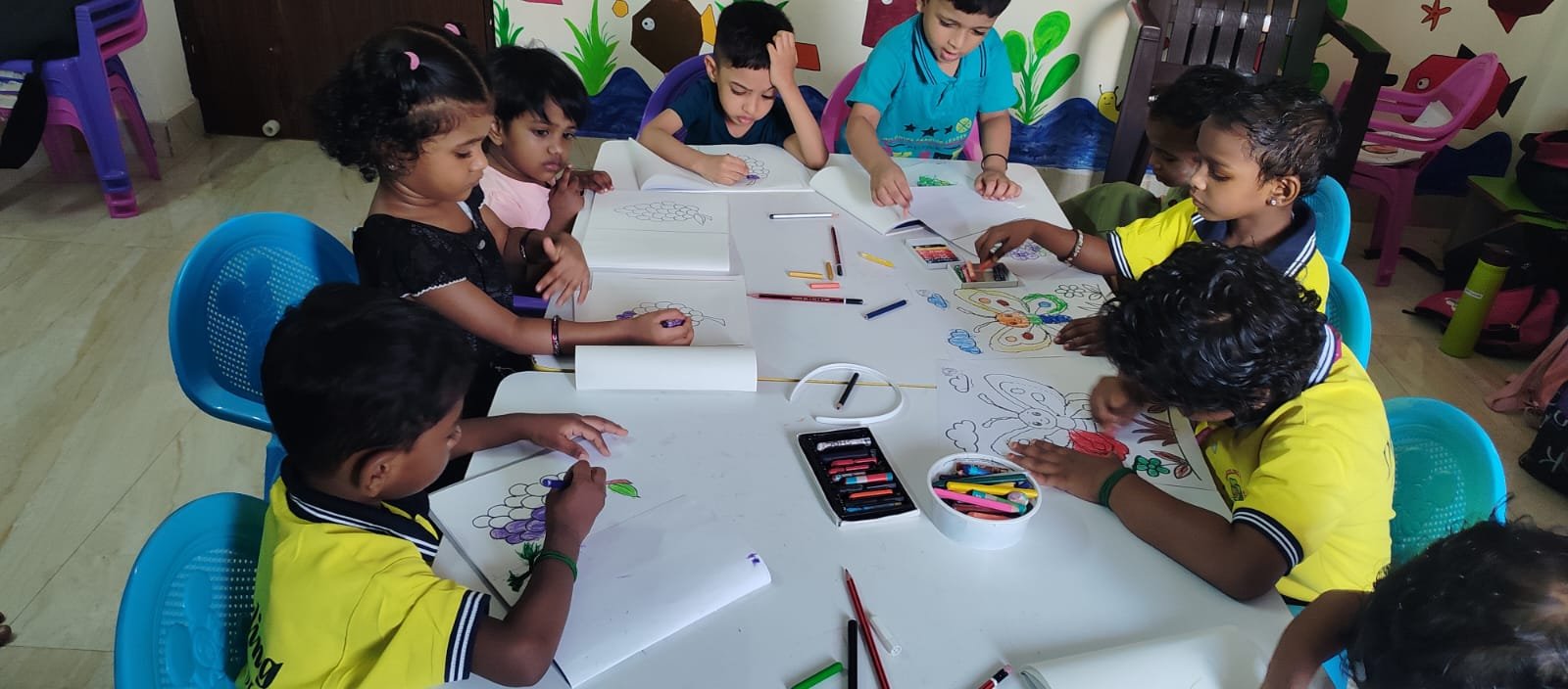 Drizzling Preschool students drawing together at a group table